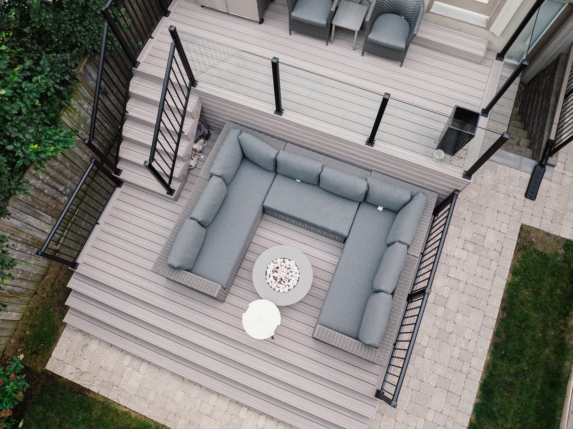 Vue aérienne d’une terrasse composite claire avec rampes noires et mobilier lounge